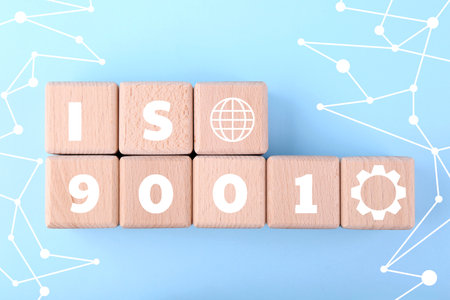 ISO 9001 Quality management systems. Wooden cubes with different icons on light blue background, top viewの写真素材