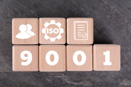 ISO 9001 Quality management systems. Wooden cubes with different icons on gray background, top viewの写真素材