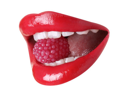 Woman with beautiful color lips holding raspberry in her mouth on white background, closeup