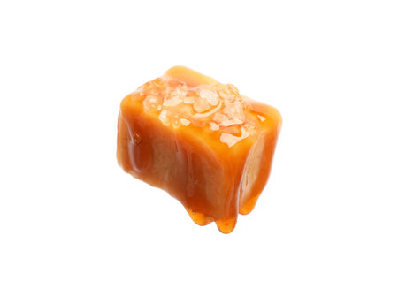 Tasty candy with salt and caramel sauce isolated on whiteの写真素材