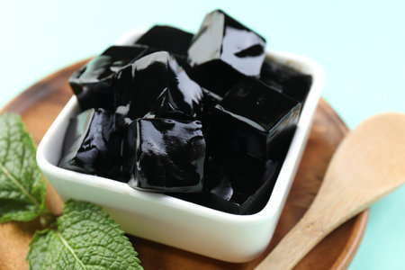 Tasty herbal jelly in bowl and mint on light blue background, closeupの写真素材