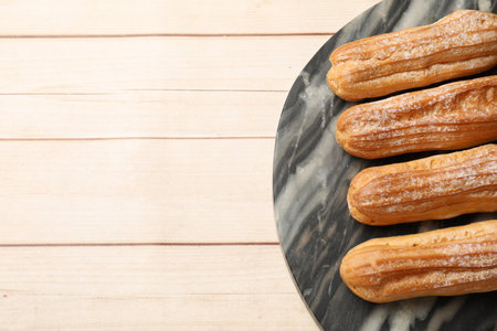 Delicious eclairs on white wooden table, top view.の写真素材