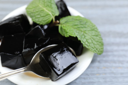 Tasty herbal jelly and mint on gray wooden table, closeup. Space for textの写真素材