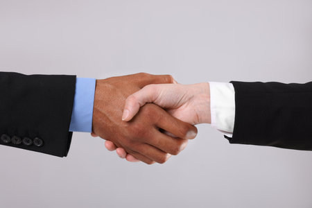 African American man shaking hands with his business partner on light gray background, closeupの写真素材