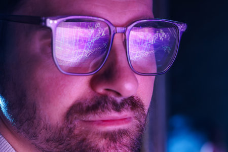 Man wearing glasses with reflection on blurred dark background, closeup. Space for textの写真素材