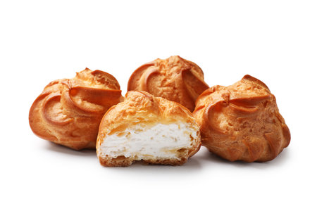 Delicious profiteroles with whipped cream isolated on whiteの写真素材
