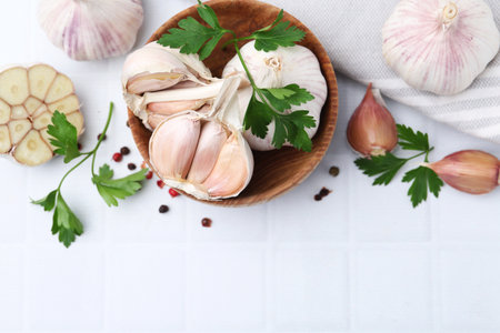 Garlic, peppercorns and parsley on white table, flat lay. Space for textの写真素材