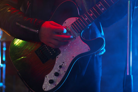 Man playing electric guitar on stage with smoke, closeupの写真素材