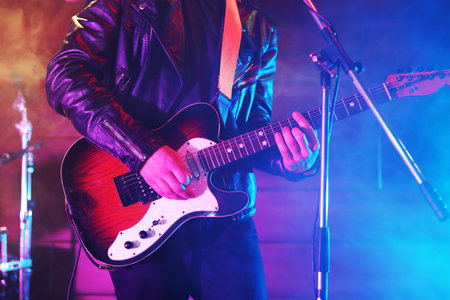 Man playing electric guitar on stage with smoke, closeupの写真素材