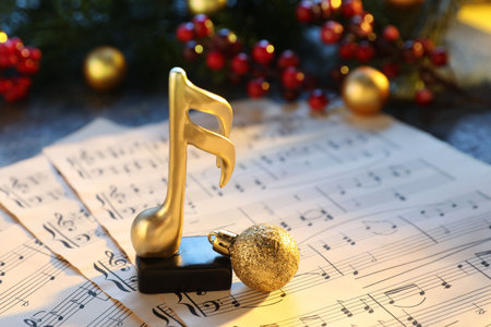 Golden music note, sheets and Christmas decor on table, closeupの写真素材