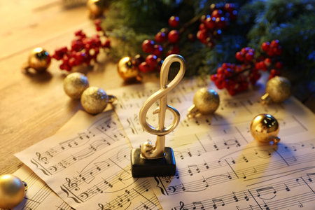 Golden treble clef, music sheets and Christmas decor on table, closeupの写真素材