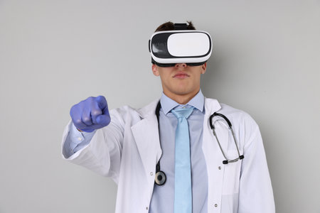 Modern technology. Doctor using virtual reality headset on light gray backgroundの写真素材