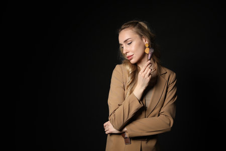 Makeup artist with brush on black background, space for textの写真素材