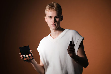 Makeup artist with contouring palette and foundation on brown background. Space for textの写真素材