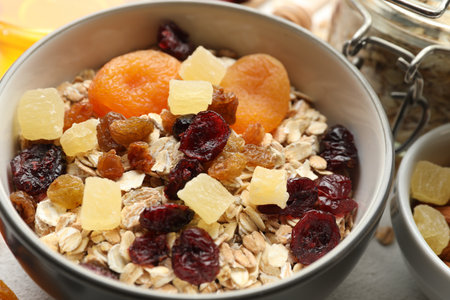 Making granola. Oat flakes, dried fruits and other ingredients on white table, closeupの写真素材
