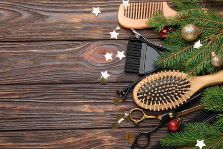 Different hairdresser's tools and Christmas decor on wooden table, flat lay. Space for textの写真素材