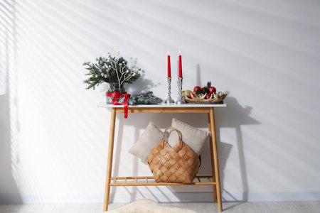 Different Christmas decor on console table near white wall indoorsの写真素材