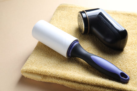 Lint roller, fabric shaver and towel on beige background, closeupの写真素材