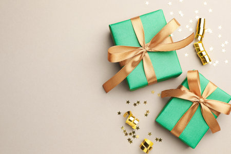 Beautiful Christmas gifts, confetti and streamers on beige background, flat lay. Space for textの写真素材