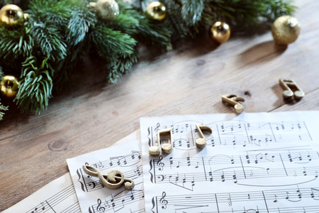 Golden music notes, sheets and Christmas decor on wooden table, closeupの写真素材