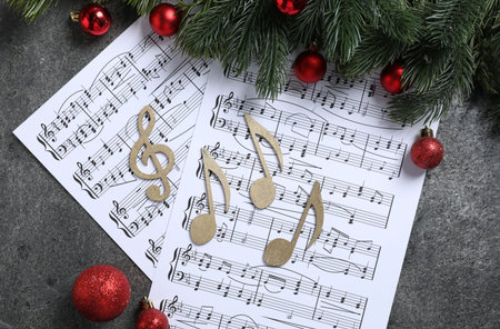 Golden music notes, sheets and Christmas decor on gray textured table, flat layの写真素材