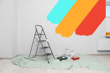 Decorator's stuff in room near wall partly painted in different shades. Choosing color for interiorの写真素材