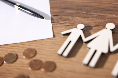 Alimony. Figures of family, coins, document and pen on wooden table, closeupの写真素材