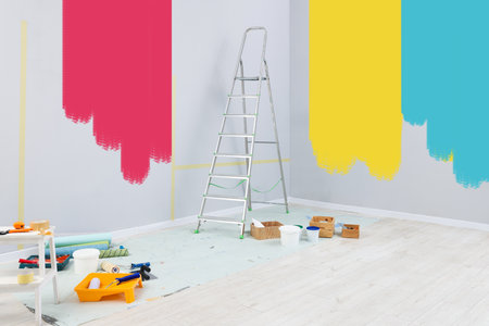Decorator's stuff in room near wall partly painted in different shades. Choosing color for interiorの写真素材