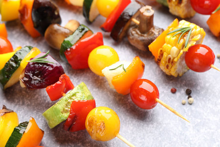 Skewers with tasty grilled vegetables on light textured table, closeupの写真素材