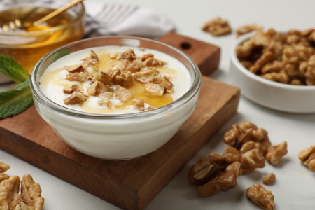 Delicious Greek yogurt with honey and walnuts served on white table, closeupの写真素材