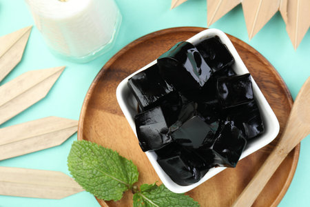 Tasty herbal jelly in bowl, mint and milk on light blue background, flat layの写真素材