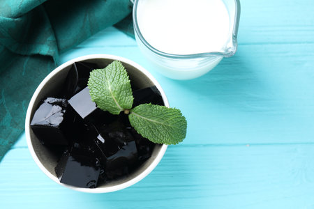 Tasty herbal jelly with mint leaves served on light blue wooden table, flat layの写真素材