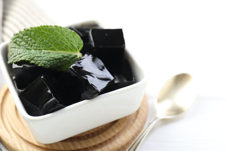 Tasty herbal jelly in bowl and mint on white table, closeupの写真素材