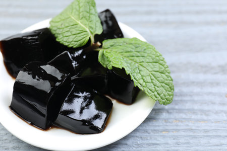 Tasty herbal jelly and mint on gray wooden table, closeup. Space for textの写真素材