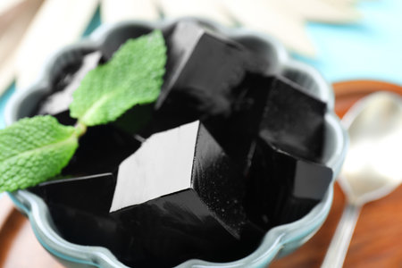 Tasty herbal jelly with mint leaves served on light blue table, closeupの写真素材
