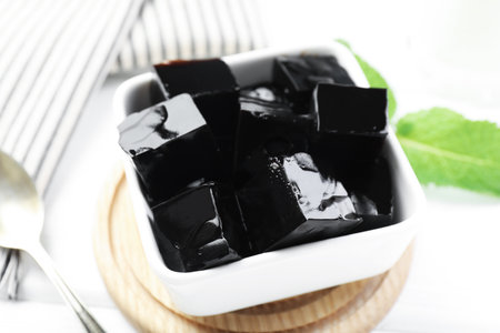 Tasty herbal jelly in bowl and mint on white table, closeupの写真素材