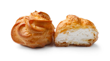 Delicious profiteroles with whipped cream isolated on whiteの写真素材