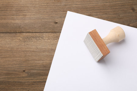 One wooden stamp and blank sheet of paper on table, top view. Space for textの写真素材
