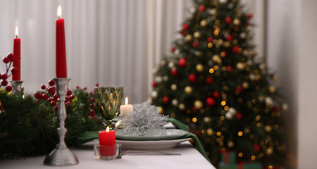 Festive table setting with Christmas decor and burning candles indoors, closeupの写真素材