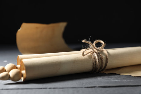 Old paper scroll on wooden table, closeup. Space for textの写真素材