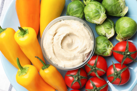 Different fresh vegetables and sauce on plate, top viewの写真素材