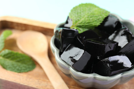 Tasty herbal jelly and mint leaves on light background, closeupの写真素材