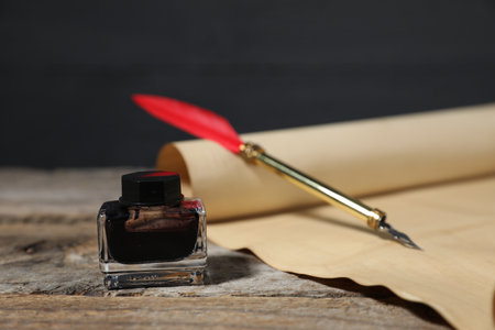 Old paper scroll, fountain pen and inkwell on wooden table, closeupの写真素材