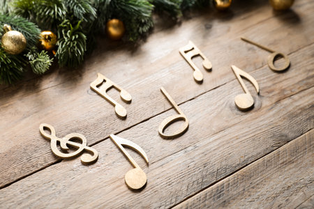 Golden music notes and Christmas decor on wooden table, closeupの写真素材