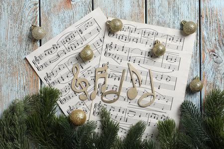 Golden music notes, sheets and Christmas decor on wooden table, flat layの写真素材