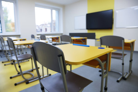 Stylish classroom with desks, chairs and TV at school, selective focusの写真素材