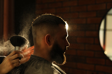 Hairstylist applying talcum powder with brush onto man's neck at salon, closeupの写真素材