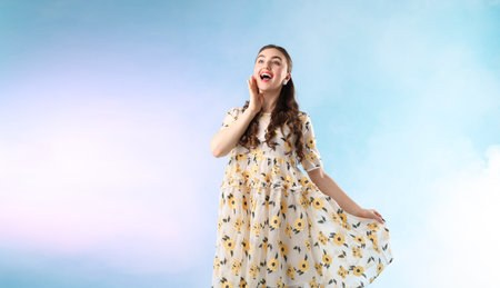 Beautifully dressed young woman on light blue backgroundの写真素材