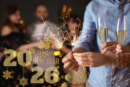 New Year 2026. Friends with glasses of sparkling wine and sparklers celebrating together, closeupの写真素材