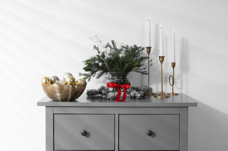 Different Christmas decor on gray cabinet near white wall indoorsの写真素材